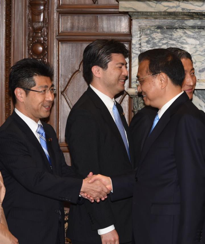 中国の李克強首相と固く握手を